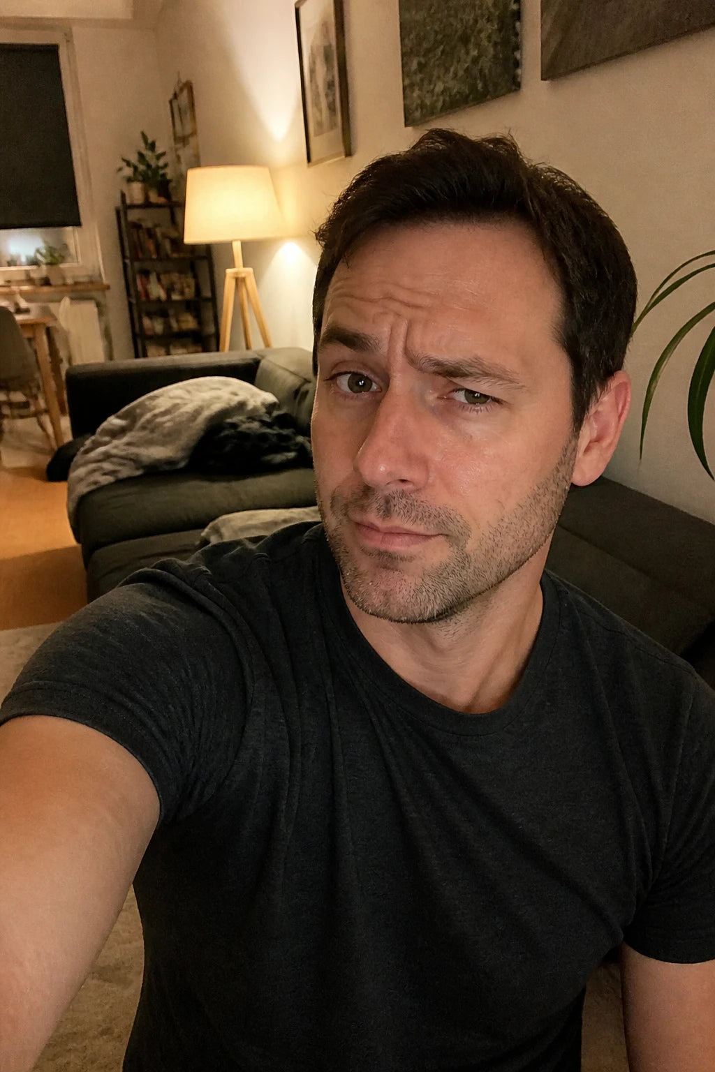 Selfie von Chris, skeptischer Blick, abends auf dem Sofa mit dem Handy in der Hand